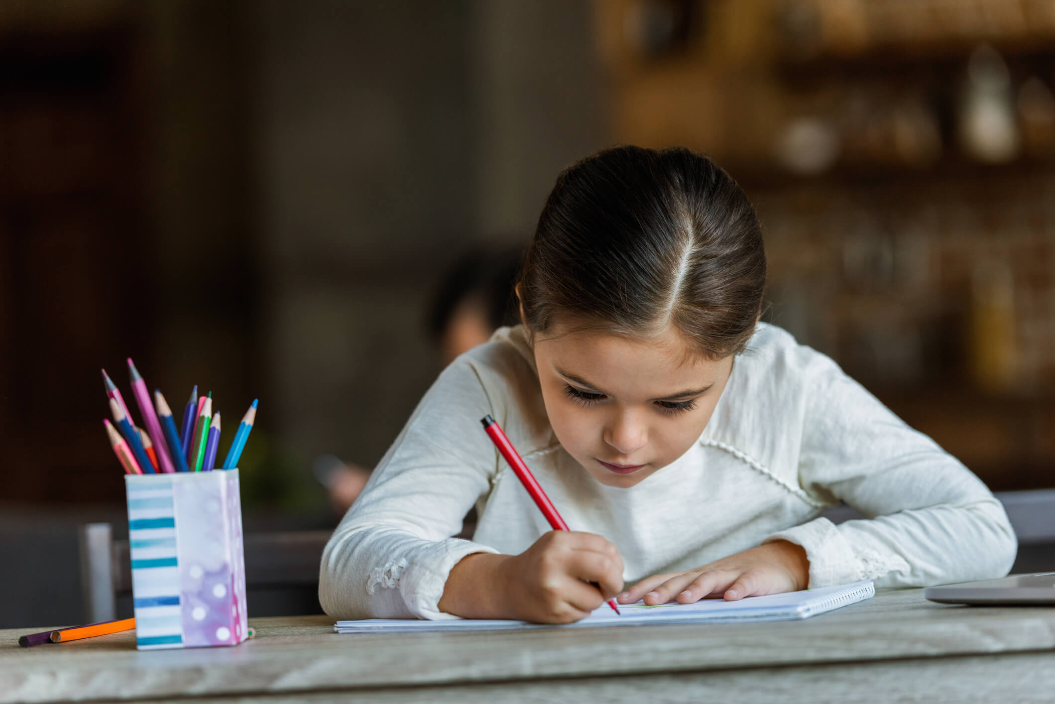 Niña con disgrafia realizando ejercicios en casa.